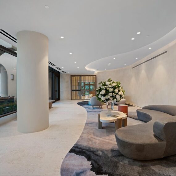 Elegant curved lobby at La Clara Palm Beach featuring sculptural seating, organic forms, and soft natural lighting.