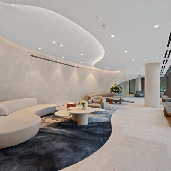 Elegant curved lobby at La Clara Palm Beach featuring sculptural seating, organic forms, and soft natural lighting.