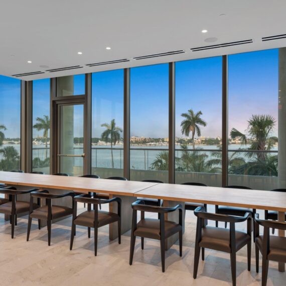 La Clara Palm Beach private dining room featuring a custom solid oak conference-style dining table and black leather armchairs manufactured by A Squared Design Studio.