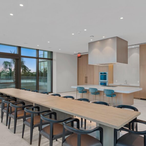La Clara Palm Beach private dining room featuring a custom solid oak conference-style dining table and black leather armchairs manufactured by A Squared Design Studio.