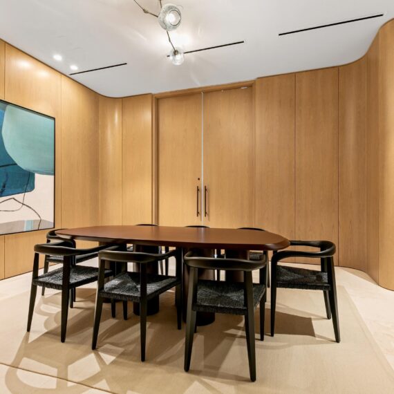 La Clara Palm Beach wine tasting room featuring a sculptural walnut table and custom black armchairs by A Squared Design Studio.